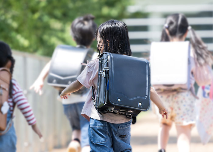 ランドセルを背負い駆ける女の子の写真